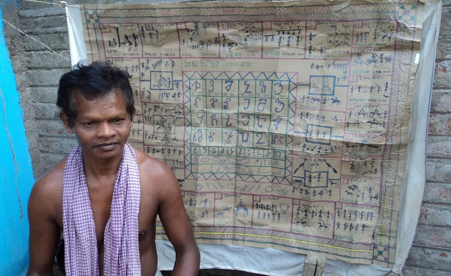 man in front of alphabet and storyboard drawing